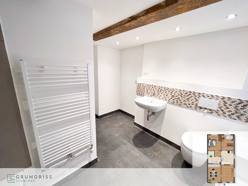 Foto eines Badezimmers im Erdgeschoss mit Dusche und Waschtisch und Handtuchheizung an der Wand, in der rechten unteren Ecke ein eingeblendeter Grundriss mit farblicher Markierung des Badezimmerbereichs.