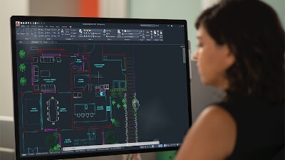 Absicht von hinten: eine Frau berbeitet einen auf einem Monitor angezeigten Grundrisses im PC.