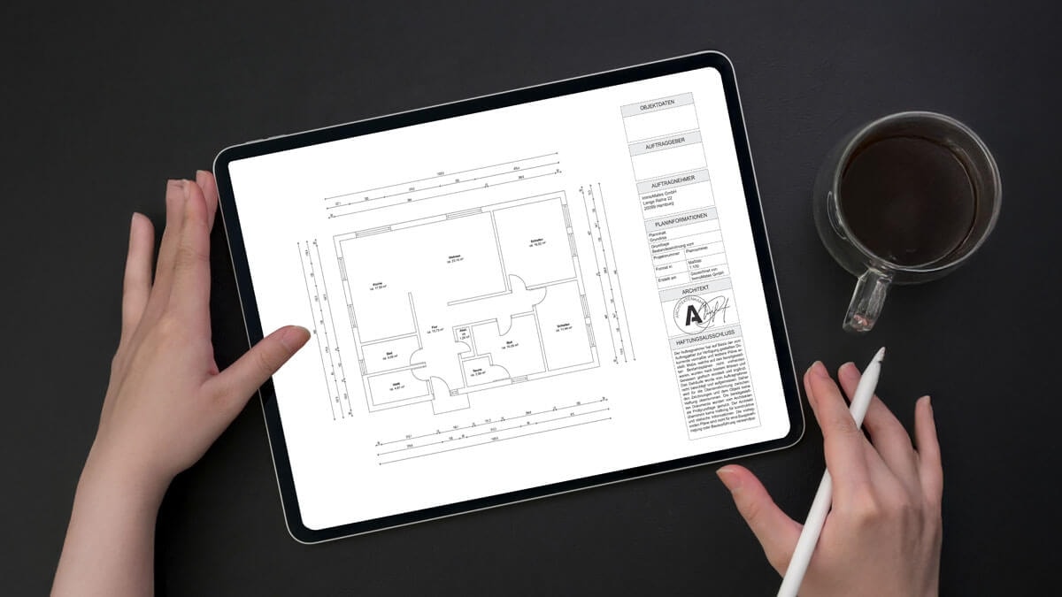 Zwei Hände rechts und links von einem Tablet auf dem ein bemaßter Grundriss zu sehen ist.