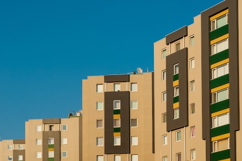Ansicht der oberen Kante eines mehrstöckigen Reihenhauses mit beiger und brauner Aussenfassade ohne Balkone.
