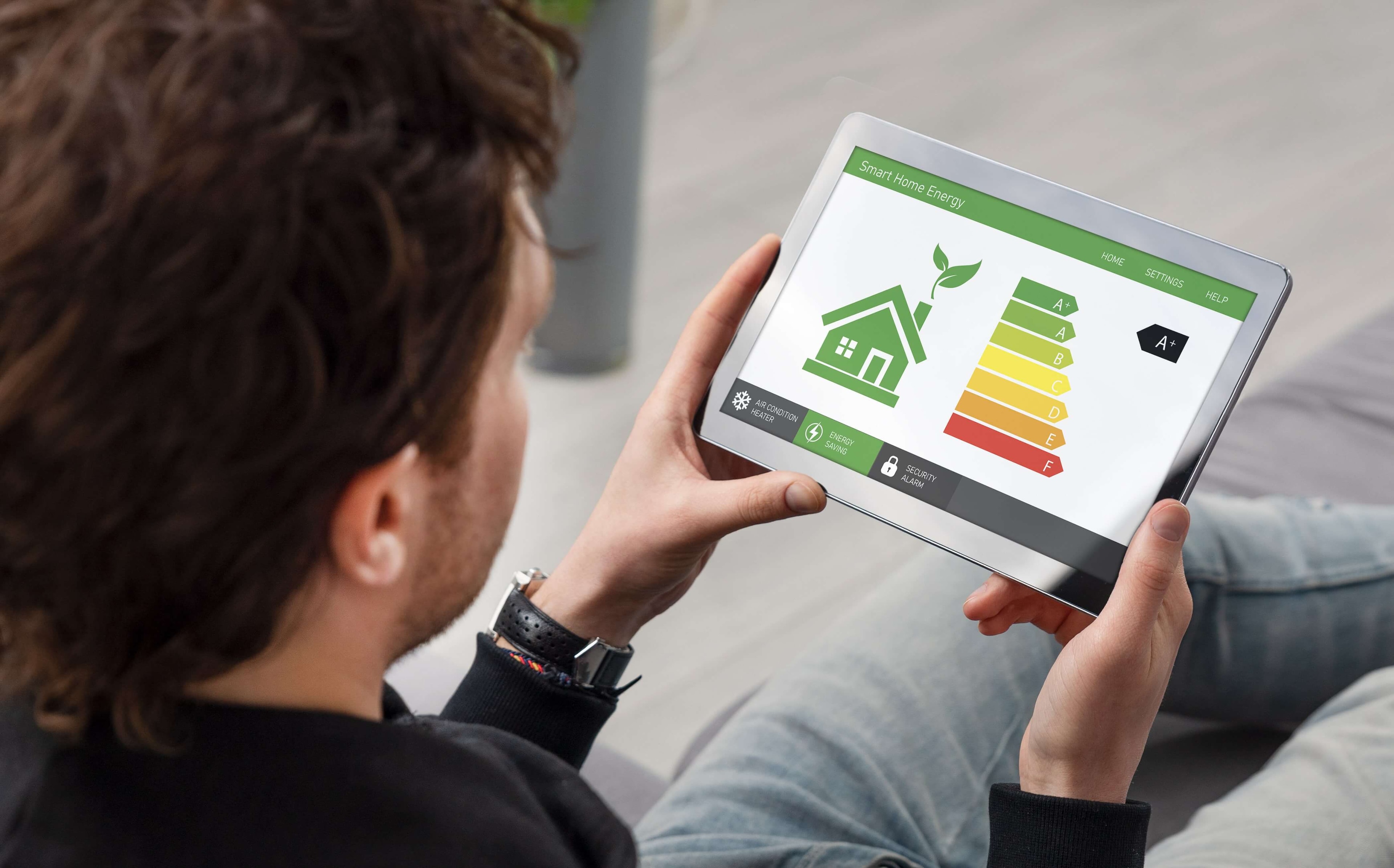 Ansicht von hinten: Mann betrachtet App für den Energie-Ausweis im Tablet.