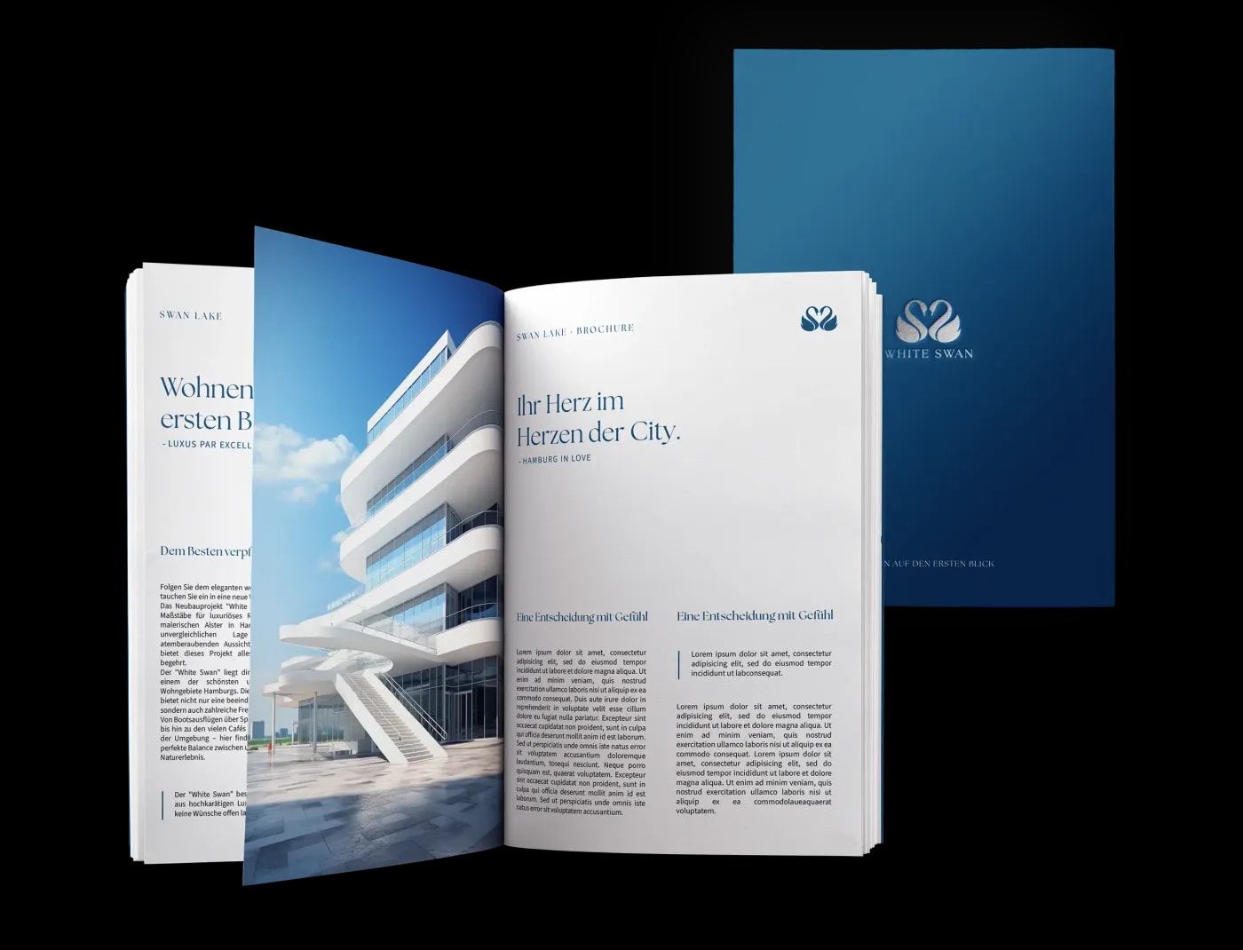 Zwei broschierte Exposés in Din A4 Hochformat zum Projekt 'Swan Lake' liegen übereinander und das obere ist auf einer Seite mit der Überschrift 'Ein Herz im Herzen der City' aufgeschlagen.