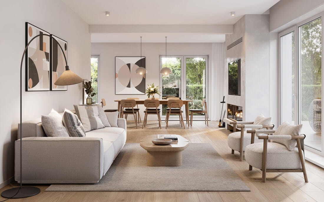 Eleganter Wohn- und Essbereich in warmen Beige- und Naturtönen mit grauem Sofa, rundem Holzcouchtisch, zwei Sesseln, Esstisch, Kunstdrucken, Kamin und großen Fensterfronten zum Garten.