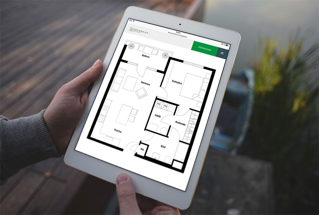 Person hält ein Tablet auf dem der Grundriss einer 2-Zimmer Wohnung, mit offener Küche, Hauswirtschaftsraum, separater Ankleide und Balkon zu sehen ist