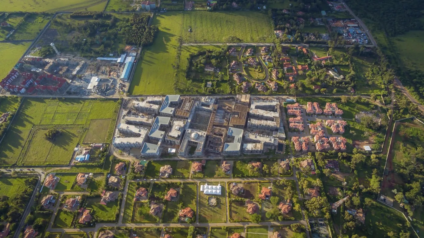 Luftaufnahme eines gemischten, städtischen Außenbezirks mit Wohnbebauung und industriellen Anlagen
