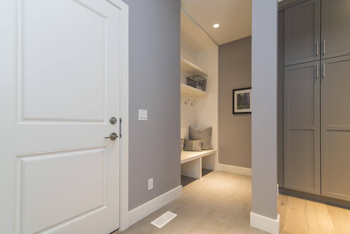 Verwinkelter Innenflur mit Laminat und hellgrauer Wandfarbe, einer Garderobe links im Bild und einem Einbauschrank rechts im Bild.