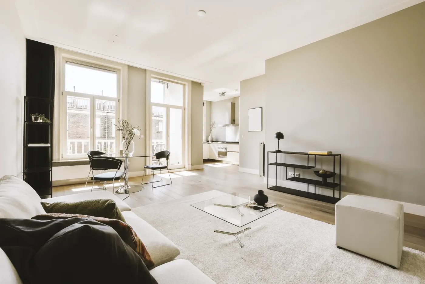 Sehr helles, verwinkeltes Wohnzimmer in modernem Style mit Anschluß an eine offene Küche im Hintergrund.