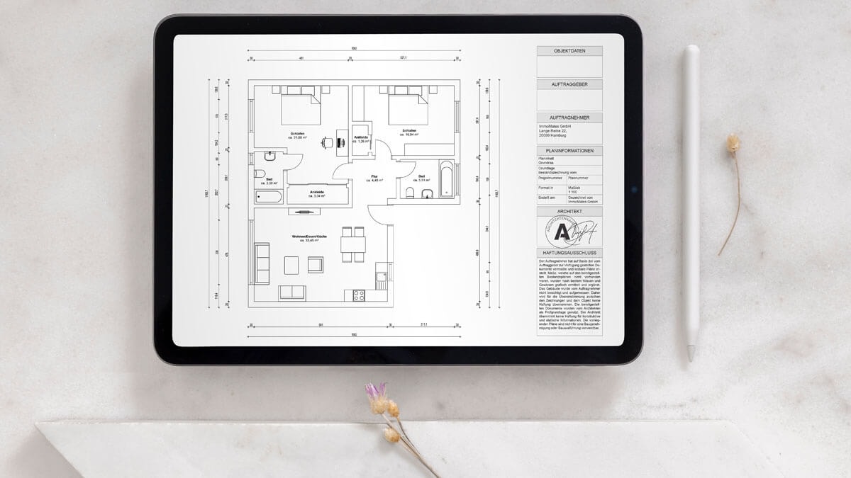 Tablet mit bemaßtem Grundriss und Architektenstempel, der eine 3-Zimmer Wohnung zeigt, die zwei Badezimmer und einen kombinierten Wohn- und Essbereich mit offener Küche besitzt.