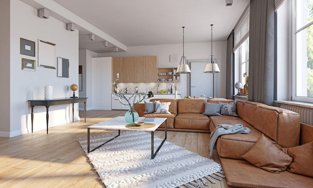 Offener Wohn- und Kochbereich mit großem braunem Lederecksofa, weißem Marmorcouchtisch und moderner Küche mit Holz- und Weißfronten im Hintergrund.